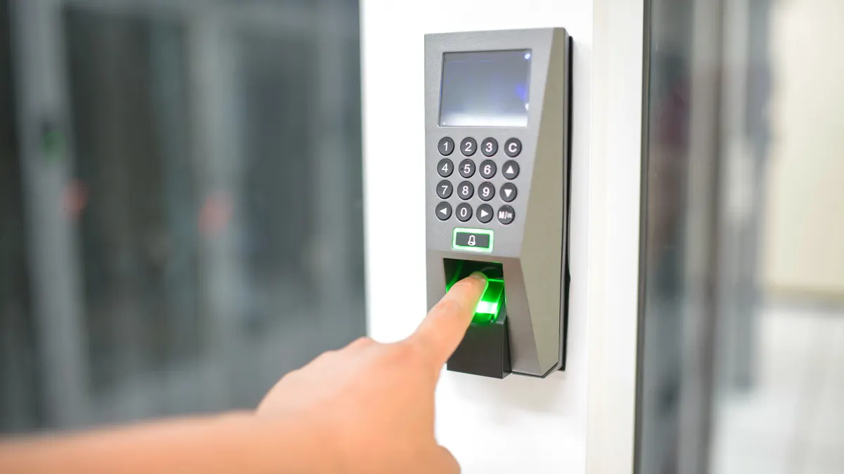 Finger using a keypad access reader on a door