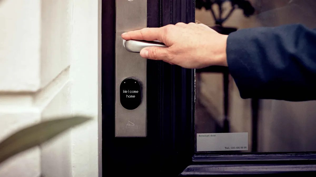 Hand opening a door with a smart lock
