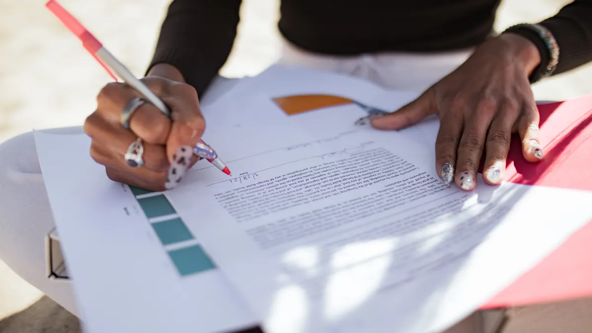 Person reviewing and annotating a printed document