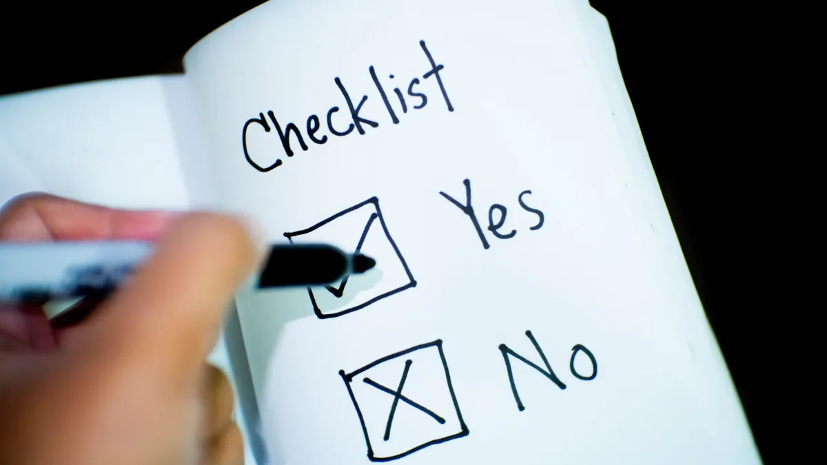 hand checking a yes/no checklist in a notebook
