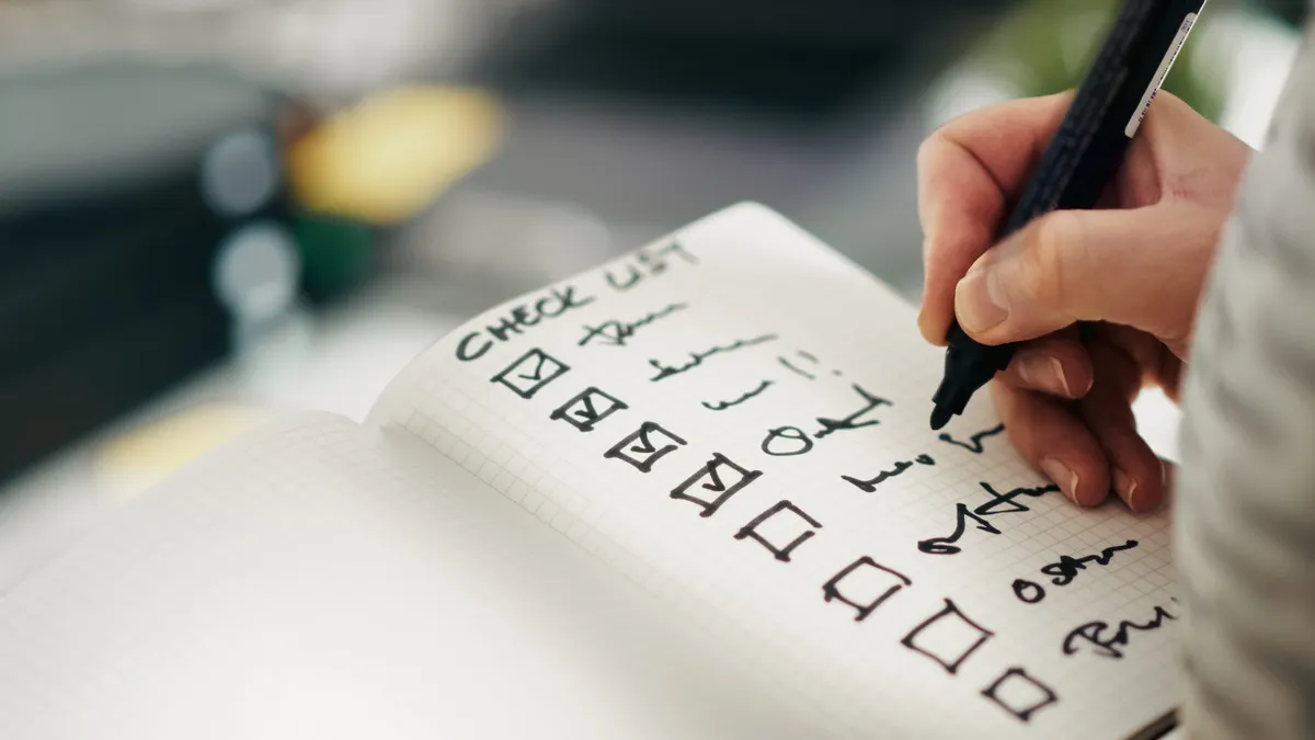 Hand writing on a checklist page in a notebook