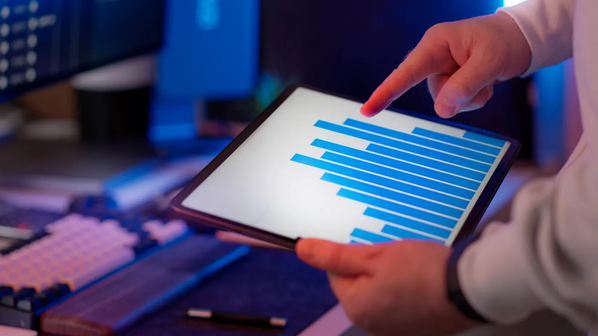 Hands pointing at a tablet with a bar chart